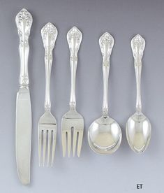 an assortment of silverware including spoons, forks and knives with designs on them