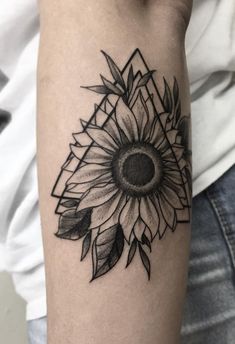 a black and white sunflower tattoo on the arm