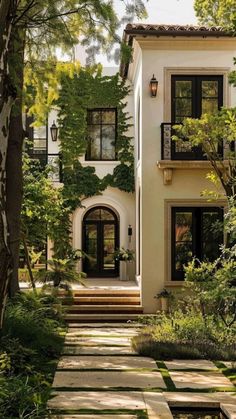 a white house surrounded by trees and bushes