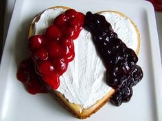 a heart shaped cake with cherries and whipped cream