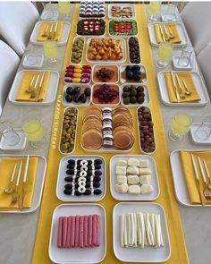 a long table filled with plates and trays of food