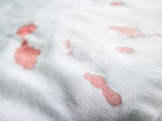 a close up of a bed sheet with red spots on it