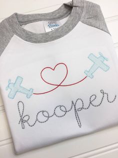 a t - shirt that says keeper with an airplane and heart on the front in red, white, and blue