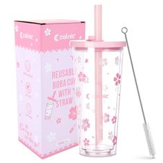 a pink cup with a straw in it next to a box