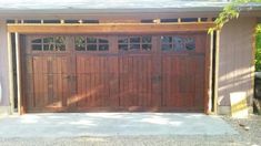 a garage with two wooden doors and windows