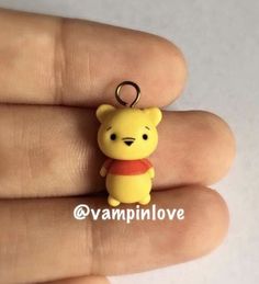 a small winnie the pooh keychain on someone's finger