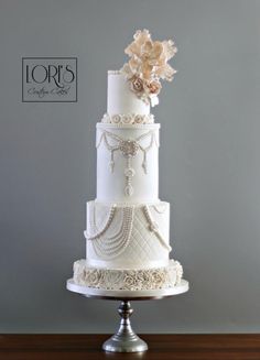 a three tiered white wedding cake sitting on top of a table