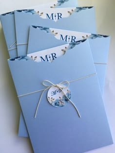 four blue envelopes with tags tied to them