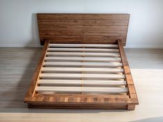 a bed with wooden headboard and foot board in a room that has hard wood flooring