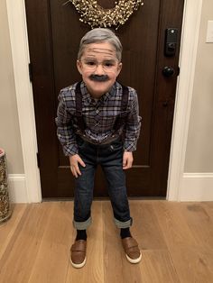 an old man is standing in front of a door with fake moustaches on his face