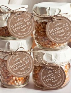 four jars filled with beans and nuts on top of a table