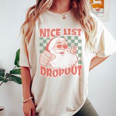 Get ready to rock the holiday season with our Nice List Dropout Comfort Colors Christmas Shirt. This retro-inspired T shirt features a playful checkered print that adds a fun twist to the Christmas design. This crewneck is crafted with comfort in mind and is made from high-quality fabric that keeps you cozy. Spread some Christmas cheer with this fun Christmas Tshirt. Comfort Colors are the most popular and trending shirts right now. With fabric that is created to be softer and feel broken in thi Rap Shirt, Christmas Jammies, Christmas Tshirt, Nice List, Vintage Santa, Holiday Trends, Holiday Sweater, Vacation Shirts