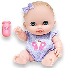 a baby doll with blue eyes sitting next to a bottle