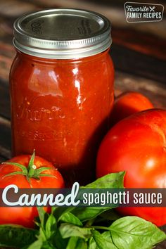 a jar filled with tomato sauce sitting on top of a table next to tomatoes and basil