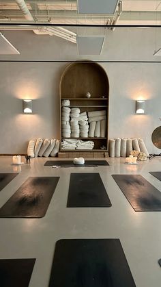 a large room with yoga mats and lights on the ceiling, as well as an open cabinet