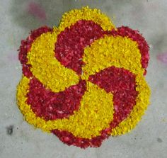 there is a yellow and red flower on the ground with it's petals sprinkled