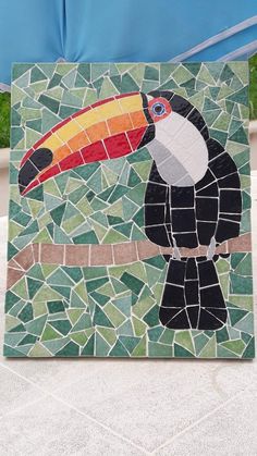 a mosaic tile with a toucan bird on it