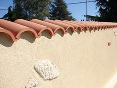 the corner of a building with a rock embedded in it's wall and trees in the background