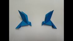 two blue origami birds sitting side by side