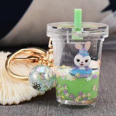 a plastic cup with a keychain on it next to a ball and some other items