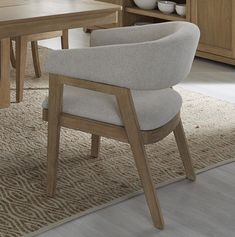 a dining room table with two chairs in front of it and a vase on the other side