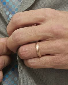 a man wearing a gold wedding band on his left hand and a silver ring on his right hand