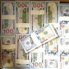 several hundred dollar bills in a wooden box