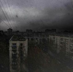 an overcast sky with buildings and power lines in the foreground under dark clouds