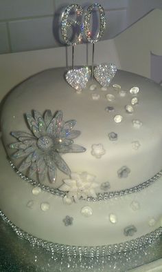 a white cake with silver decorations on top and the number 60 on it's side