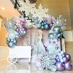 there are balloons and snowflakes on display in this room with a white cart