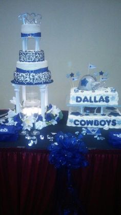 three tiered wedding cake with blue and white decorations on the top, sitting on a table