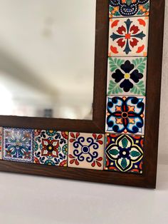 a mirror that has some colorful tiles on it