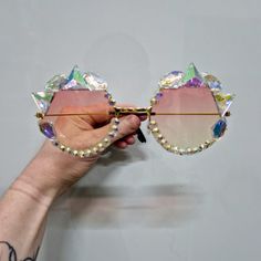 Make a statement with our jeweled iridescent sunglasses, the ultimate accessory for parties, festivals, weddings, raves, and events.  Handcrafted by a professional prop maker, these round glasses are adorned with dazzling jewels, adding a touch of glamour to any outfit.  Customisable to your liking, they're not just sunglasses--they're a reflection of your unique style.  Stand out from the crowd with these eye-catching shades that elevate any occasion. Rave Party Sunglasses With Mirrored Lenses, Rave Festival Sunglasses With Tinted Lenses, Rave Style Festival Sunglasses With Tinted Lenses, Rave Festival Sunglasses With Mirrored Lenses, Rave Sunglasses With Gradient Lenses For Party, Glamorous Party Sunglasses With Mirrored Lenses, Glamorous Party Sunglasses With Gradient Lenses, Gold Party Sunglasses With Adjustable Fit, Party Sunglasses With Bling And Glass Material