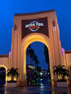 the entrance to universal studios is lit up at night