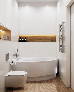 a bathroom with a toilet, bathtub and wooden flooring is pictured in this image