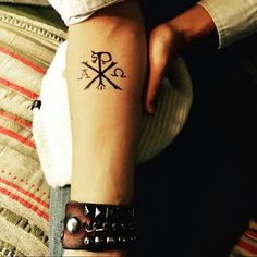 a woman's arm with a tattoo on it that has an arrow and compass