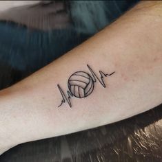 a volleyball tattoo on the arm with heartbeats and ball in it's center