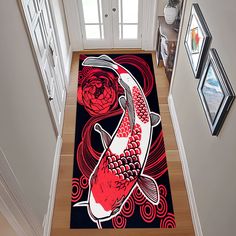 a fish rug is on the floor in front of a white door and framed pictures