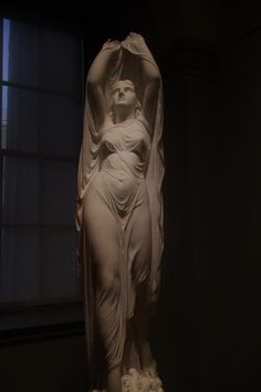 a statue is shown in the dark with light coming from it's window sill