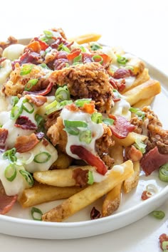 a white plate topped with french fries covered in toppings