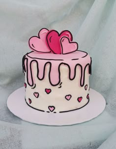 a pink and white cake with hearts on top