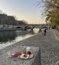 a plate of food sitting on the side of a river next to a stone walkway