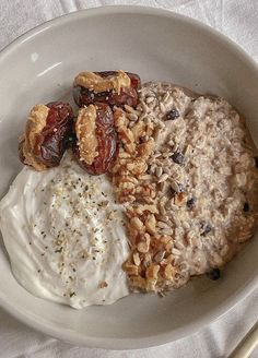 an oatmeal with raisins, nuts and yogurt in a bowl