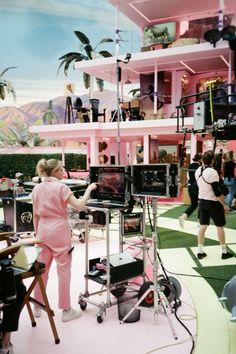 a woman standing in front of a television set with people around her looking at it