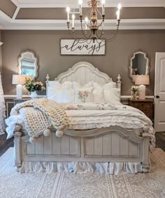 a white bed sitting under a chandelier in a bedroom