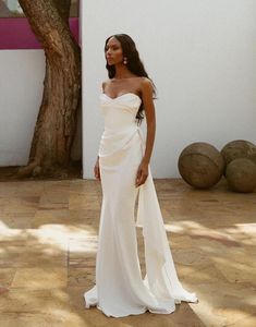 a woman in a white dress standing on the ground