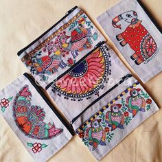 four embroidered napkins with colorful designs on them