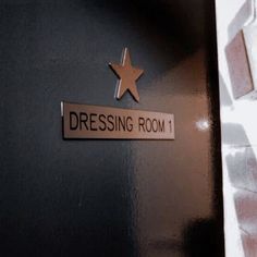 there is a sign that says dressing room 1 on the side of a door with a star above it