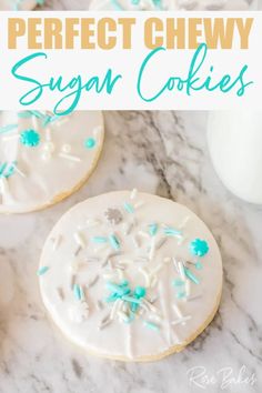 two sugar cookies with blue sprinkles and white frosting on top, next to a glass of milk