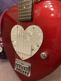 a red guitar with a heart on it